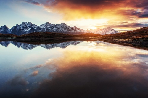 Fototapeta oslnivý západ slunce nad horským jezerem