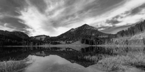 Obraz jezero pod kopci v černobílém provedení